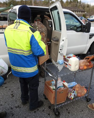 People unloading donations from truck to local food donation center